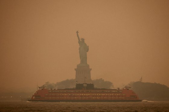 6일(현지시간) 캐나다에서 번진 산불 연기 여파로 미국 뉴욕시 자유의 여신상 일대 대기가 뿌옇게 변해 있다.로이터=연합뉴스