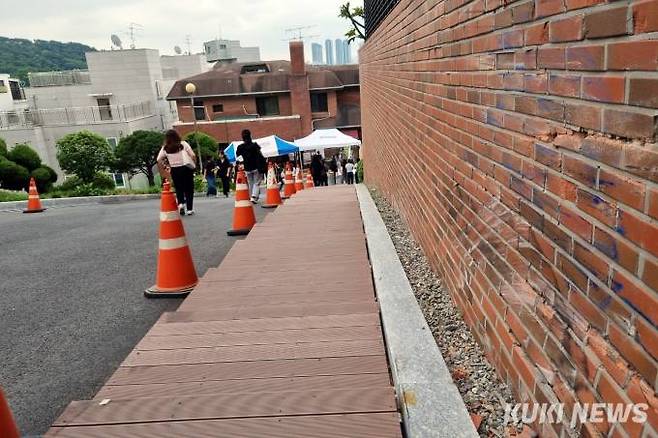 지난 5일 서울 성북구 동덕여자대학교 내 쓰레기장이 있는 언덕에서 발생한 교통사고 현장 담벼락. 8일 오전 현장 한 쪽에 사고로 사망한 대학생 A씨를 추모하는 공간이 마련돼 있다.   사진=임지혜 기자