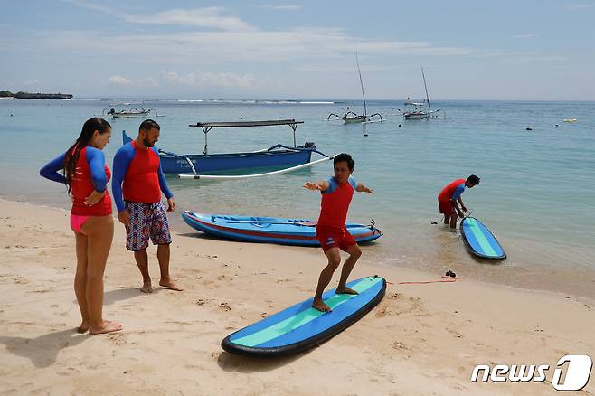 17일(현지시간) 인도네시아 발리 누사 두아 해변에서 관광객들이 서핑 강습을 받고 있다. ⓒ 로이터=뉴스1 ⓒ News1 정윤영 기자