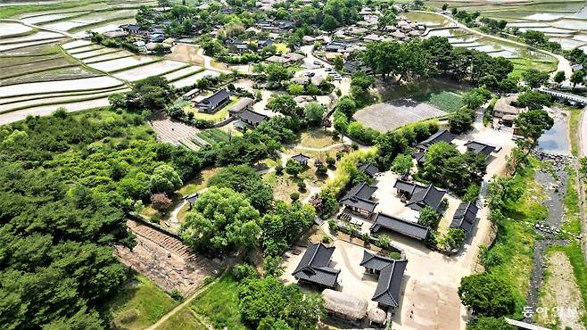 충남 아산시 송악면의 외암마을 전경. 좌우 양쪽 논밭 사이로 길다랗게 마을이 형성된 명당 터다. 마을 진입구인 돌다리(오른쪽 상단) 아래로 반계천이 마을을 휘감아 가듯 흐르고 있다. 안영배 기자