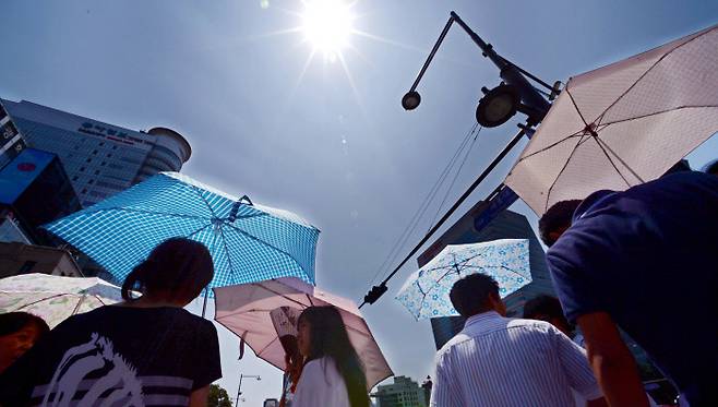 때 이른 무더위 속에 거리를 지나는 시민들이 양산으로 강렬한 햇빛을 가리고 있다. 경향신문 자료사진