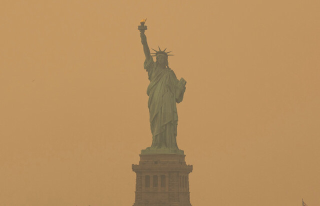 미국 뉴욕 ‘자유의 여신상’이 7일(현지시간) 캐나다에서 발생해 남하한 주황색 산불 연기에 가려 있다.  AP연합뉴스