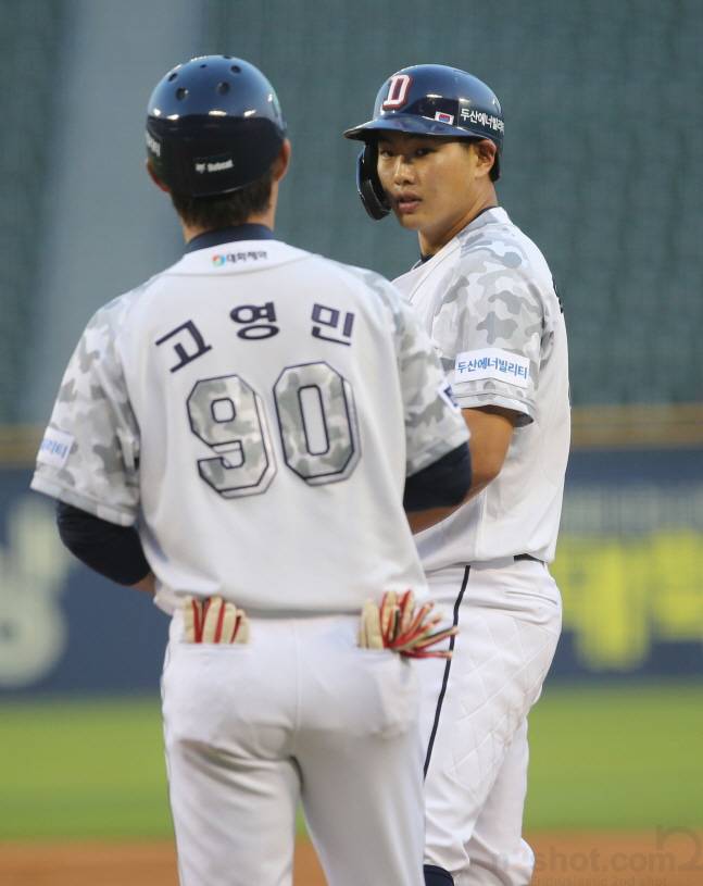 홍성호(오른쪽)가 첫 타석 안타 후 고영민 코치와 이야기를 나누고 있다. /사진=두산 베어스