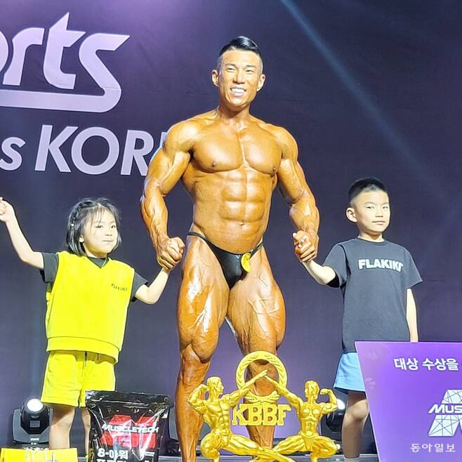 2023 미스터&미즈 코리아 남자 90kg이상급에서 우승한 뒤 대상까지 받은 김진호 씨가 아들 딸과 함께 포즈를 취했다. 대한보디빌딩협회 제공.