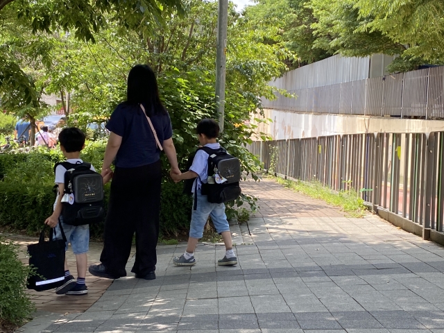 지난달 31일 오후, 정재초 앞에서 한 학부모가 아이 둘을 데리고 하교하고 있다. 오른쪽의 보행자전용도로는 폭이 좁아 주민들은 왼쪽의 '공원 길'을 택했다. 김영은 인턴기자