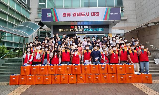 SK이노베이션 계열 구성원들이 ‘행복나눔 사랑잇기’ 대면 봉사활동에 참여해 대전시 노인복지관 앞에서 기념촬영을 하고 있다. SK이노베이션 제공