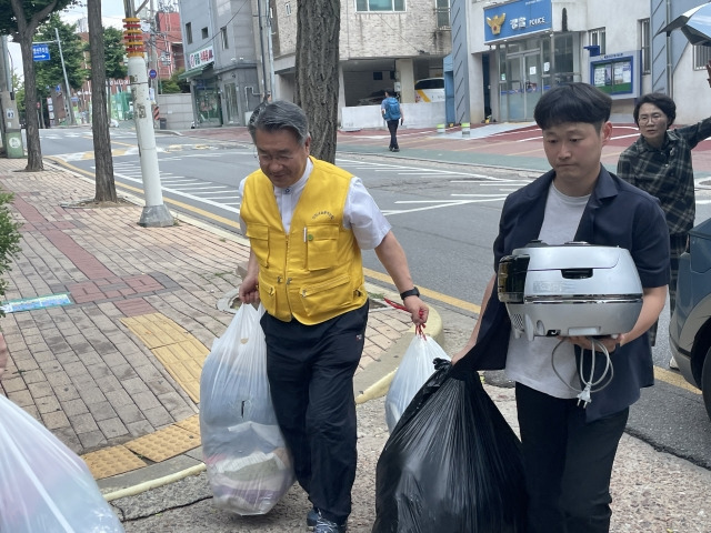 이준모 목사(왼쪽)와 해인교회 성도가 기부품을 운반하고 있다.