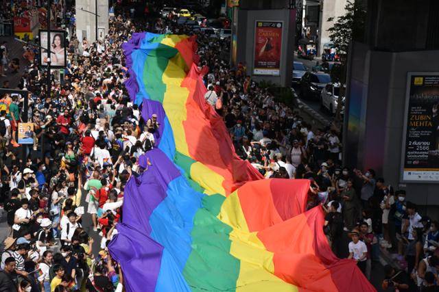 4일 태국 방콕에서 열린 성소수자 축제에서 시민들이 LGBTQ를 의미하는 무지개색 대형 깃발을 들고 행진하고 있다. 방콕=허경주 특파원