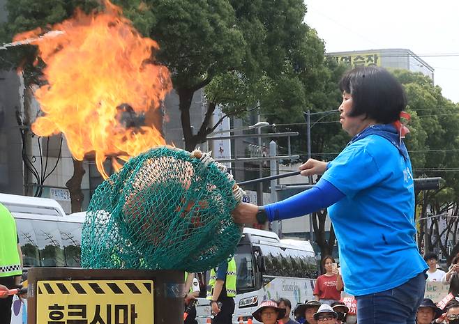 13일 오후 제주시 노형오거리에서 열린 ‘일본 핵오염수 해양투기 저지 제주 범도민대회’에서 제주도해녀협회 고송자 사무국장이 항의 표시로 테왁(해녀 물질 기구)을 태우고 있다. 연합뉴스