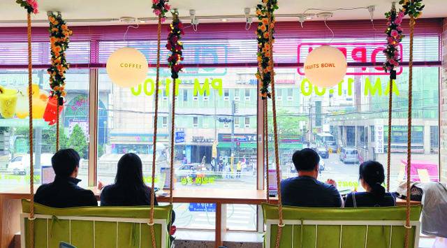 방문객들이 12일 인천 ‘캔모아’ 부평직영점의 그네의자에 앉아서 창밖을 보며 음료수를 마시고 있다.