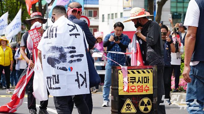 13일 제주시 노형동 주제주일본국총영사관 앞에서 진행된 '일본 핵오염수 해양투기 저지 제주 범도민대회' 집회 현장에서 시민들이 욱일기를 찢고 불태우고 있다. 고상현 기자