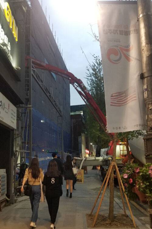 지난달 4일 서울 용산구 이태원의 신축 건물 공사&nbsp;현장에서&nbsp;콘크리트펌프카가 콘크리트를 붓는 커다란 팔 모양의 높이 5,&nbsp;6m 압송관(붐) 아래를 시민들이 아슬아슬 지나가고 있었다. 김청중 기자
