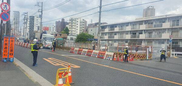 지난달 일본 도쿄 신주쿠구의 한 도로 확장 공사현장에서 노란색 형광&nbsp;띠를 착용한 안전요원 4명이 배치되어 있다. 공사 현장의 다른 편에도 안전요원이 2명이 배치되어 식별할 수 있는 안전요원만 6명이 보행자 안내와 차량 통제를 하고 있다. 도쿄=강구열 특파원