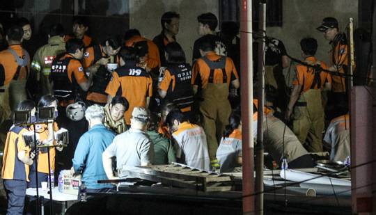 대구 서구 중리동의 한 재활용 공장 화재 현장에서 소방관들이 컵라면으로 끼니를 때우고 있다. 연합뉴스