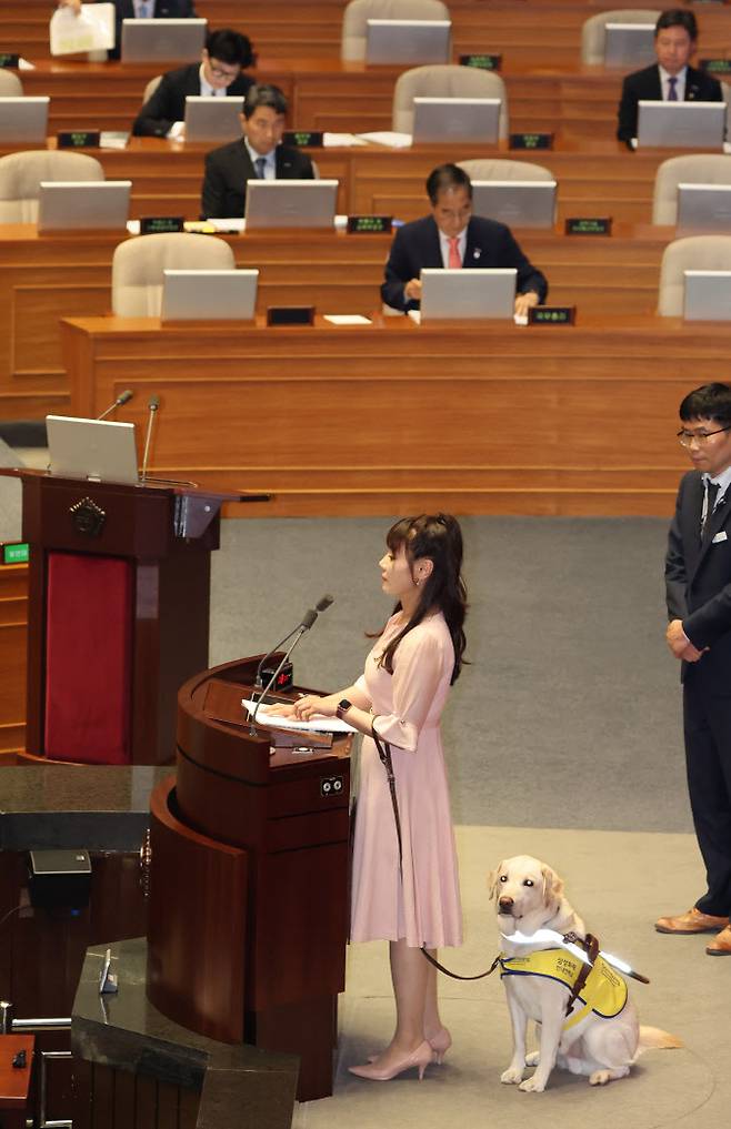 김예지 국민의힘 의원이 지난 14일 국회 본회의에서 대정부 질문을 하고 있다. 김 의원 옆은 안내견 조이. (사진=연합뉴스)