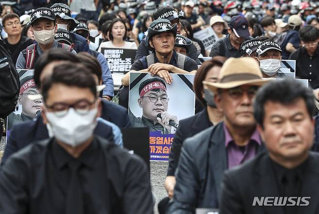 [서울=뉴시스] 김근수 기자 = 건설노조 故 양회동씨의 장례절차가 시작된 17일 서울 중구 세종대로 인근에서 열린  故 양회동 열사 범국민 추모대회에서 조합원들이 추모영상을 시청하고 있다. 2023.06.17. ks@newsis.com