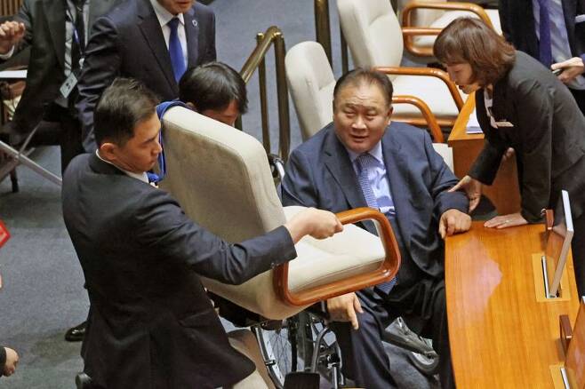19일 국회 본회의장에서 관계자가 부서진 민주당 이상민 의원의 의자를 옮기고 있다. 이 의원의 의자는 이 의원이 앉는 도중 부서졌다. 사진=서동일 기자
