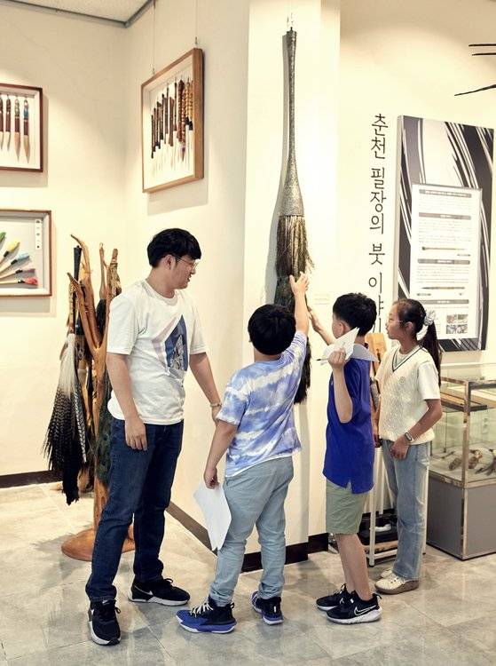 공작의 꼬리 깃털로 만든 거대한 붓을 살펴보는 소중 학생기자단. 붓이야기박물관에서는 고정관념을 깨는 전통 붓도 만날 수 있다.