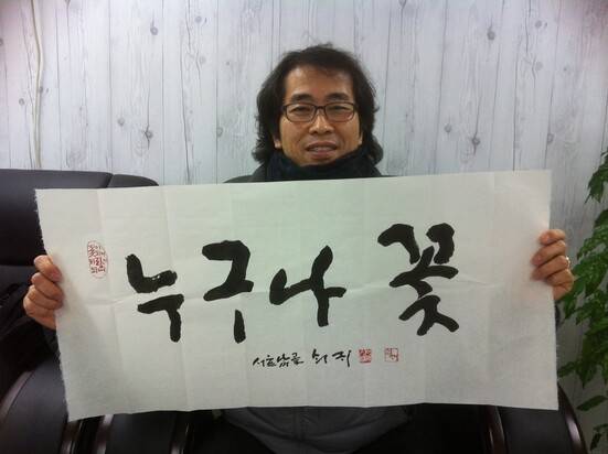 교사 조원배씨가 고 신영복 선생에게 ‘누구나 꽃’ 글씨를 선물받고 찍은 사진. 조씨는 이를 학급 급훈으로 자주 사용했다. 조원배 제공