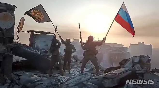 [바흐무트=AP/뉴시스] 러시아 용병 기업인 바그너그룹의 수장 예브게니 프리고진이 미국 언론 폴리티코에 미국산 F-35 전투기 구매를 중개해달라고 요청했다. 사진은 지난달 20일(현지시간) 바그너그룹 소속 군인들이 우크라이나 바흐무트의 손상된 건물 위에서 러시아 국기와 바그너 깃발을 흔드는 모습. 2023.06.20.