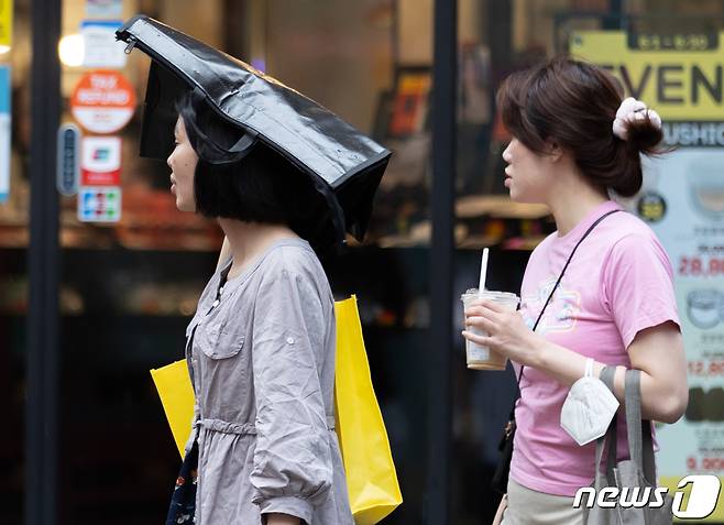 서울 도심에 비가 내리는 20일 오후 서울 중구 명동거리에서 외국인 관광객들이 발걸음을 재촉하고 있다. 2023.6.20/뉴스1 ⓒ News1 이재명 기자