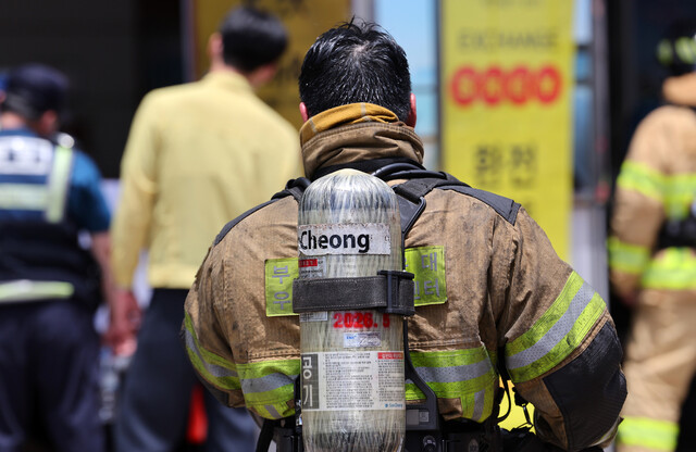 지난 20일 오전 부산 해운대구 한 호텔 화재현장에서 화재진압에 투입된 소방대원이 땀으로 젖어 있다. 연합뉴스