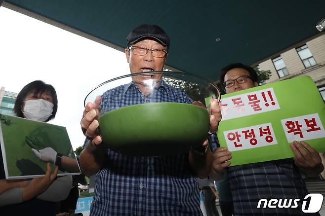 낙동강네트워크·낙동강대구경북네트워크 등 영남권 환경단체 회원들이 지난해 8월1일 대구 달성군 매곡정수장 인근 낙동강에서 퍼온 물을 투명 용기에 따른 뒤 대구시장 항의방문과 서한문 전달을 시도하며 청사 정문 앞에서 청원경찰과 대치하고 있다. /뉴스1 ⓒ News1 공정식 기자