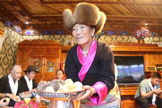 중국 티베트족 노인 19일 중국 티베트 산난시의 한 체험마을에서 티베트족 노인인 손님들에게 음식을 건네고 있다. [촬영 한종구 특파원]