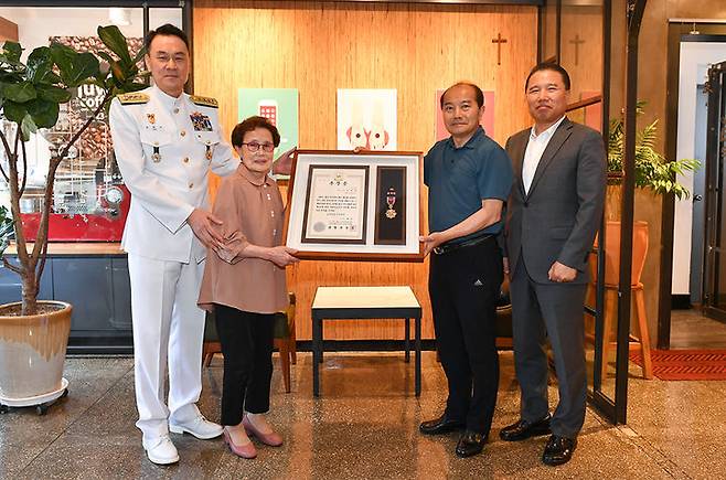 [부산=뉴시스] 김명수(중장) 해군작전사령관인 23일 부산에 거주하는 6·25전쟁 참전용사인 고 김재택 상사의 가족을 만나 무공훈장(금성화랑)을 전달하고 있다. (사진=해군작전사 제공) *재판매 및 DB 금지