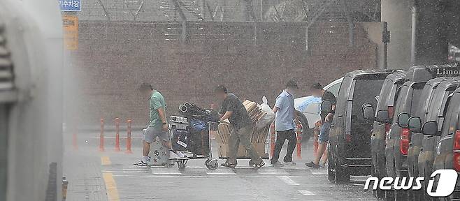 제주를 비롯한 남부지방에 장마가 시작된 25일 제주국제공항에서 관광객들이 장맛비를 피하며 급하게 발걸음을 옮기고 있다.2023.6.25/뉴스1 ⓒ News1 강승남 기자