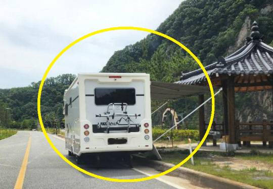 지난 25일 충북 영동의 한 2차선 도로 위에 설치된 캠핑카가 정자를 향해 어닝을 펼친 모습. 사진=온라인 커뮤니티 갈무리