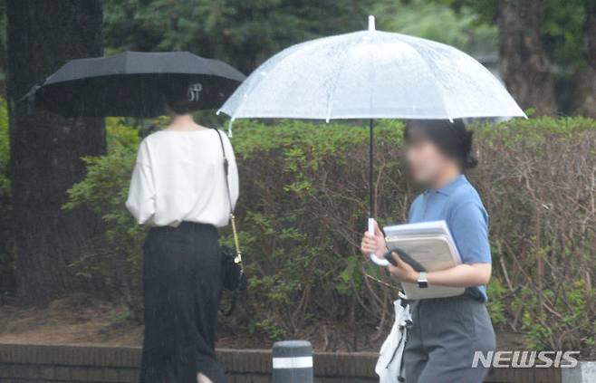 [전주=뉴시스] 김얼 기자 = 전국적으로 장맛비가 내리기 시작한 26일 전북 전주시 전북대학교 교정에서 시민들이 우산으로 비를 피하며 길을 지나고 있다. 2023.06.26. pmkeul@nwsis.com