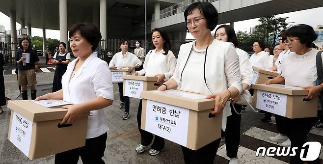 대한간호협회 간호사들이 26일 오전 세종시 어진동 보건복지부를 항의 방문하여 보건복지부의 간호법 허위사실 유포, 불법진료 묵인 등을 규탄하는 기자회견을 마친뒤 항의 서한 전달 및 면허증을 보건복지부에 반납하고 있다. 2023.6.26/뉴스1 ⓒ News1 김기남 기자