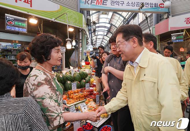 이재명 더불어민주당 대표가 27일 오후 서울 관악구 신사시장에서 열린 여름철 폭우, 폭염, 폭등 대책 마련을 위한 상인 간담회에 참석하며 시민들과 인사를 나누고 있다. (공동취재) 2023.6.27/뉴스1 ⓒ News1 송원영 기자