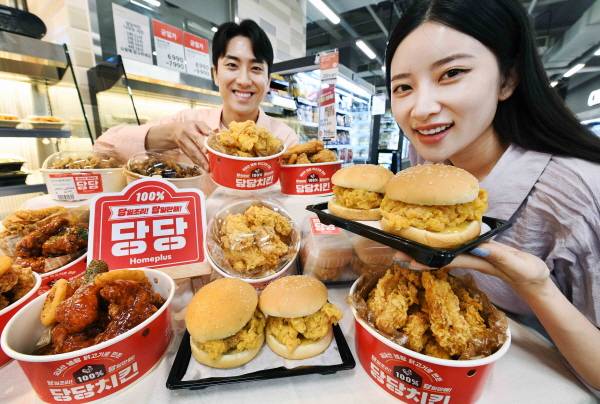 홈플러스 매장에서 모델들이 당당 순살치킨 트윈버거과 후라이드 순살치킨을 소개하고 있다. [사진제공=홈플러스]