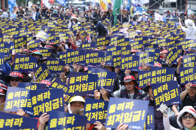 ▲ 27일 오후 서울 중구 남대문 인근에서 한국노총이 연 노조간부 결의대회에서 조합원들이 최저임금 인상과 정부의 노동 탄압 중단을 촉구하며 손팻말을 들고 있다. 연합뉴스