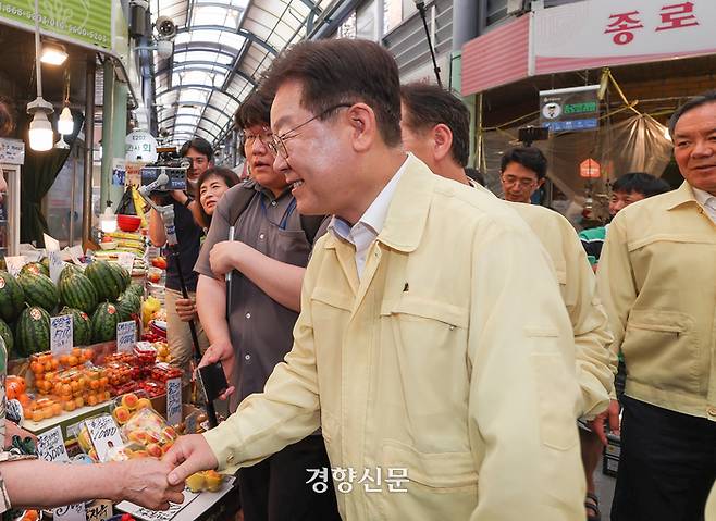 이재명 더불어민주당 대표가 27일 관악구 신사시장에서 한 시민과 기념촬영을 하고 있다.   사진공동취재단