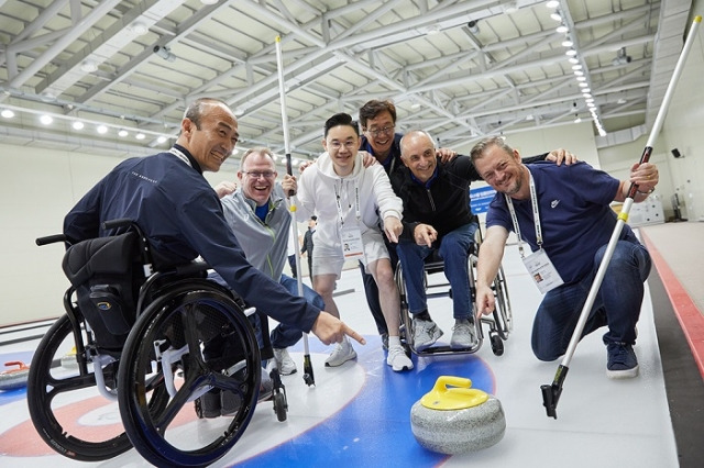 BDH재단 배동현 이사장(왼쪽 세 번째)이 미니패럴림픽 스포츠나이트에서 IPC 앤드류 파슨스 위원장(오른쪽 첫 번째)을 비롯한 IPC·KPC 관계자들과 컬링 경기를 하고 있다. BDH재단 제공