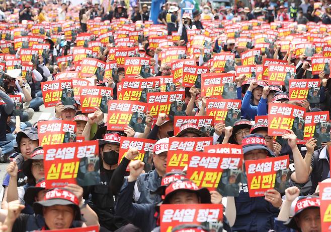 27일 오후 서울 중구 남대문 인근에서 한국노총이 연 노조간부 결의대회에서 조합원들이 최저임금 인상과 정부의 노동 탄압 중단을 촉구하며 손팻말을 들고 있다. [연합]