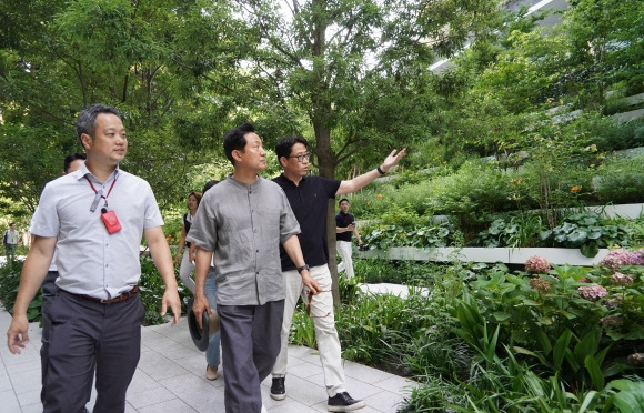 일본을 방문 중인 오세훈(가운데) 서울시장이 지난 25일 도쿄 도라노몬 힐스에서 도심재개발 과정에서 확보된 도심 녹지공간과 관련해 관계자의 설명을 듣고 있다. 서울시 제공