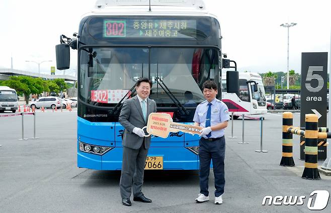 28일 제주국제공항 주차장 인근에서 열린 제주시 도심구간 급행버스 개통식에서 오영훈 지사(왼쪽)가ㅜ급행버스 운전기가인 김대은씨에게 모형 열쇠를 전달하고 있다.(제주도청 제공)/뉴스1