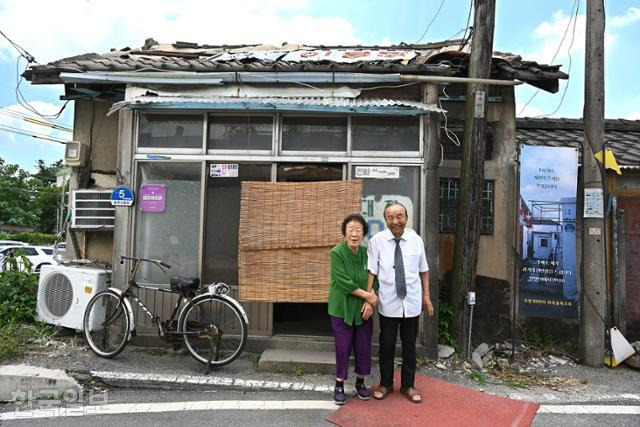 이종완 할아버지, 송기철 할머니 부부가 60년간 영업하고 있는 대창이용원 앞에서 포즈를 취하고 있다. 무게를 이기지 못한 간판은 지붕 위에 얹어 놓았다.