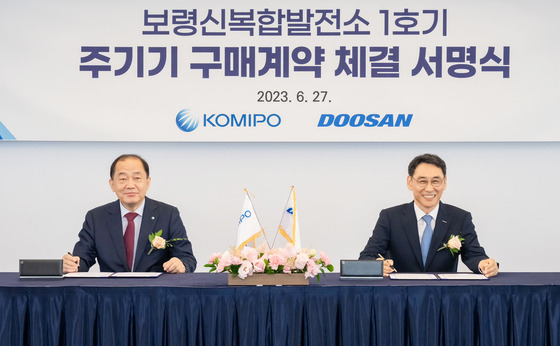 Korea Midland Power CEO Kim Ho-bin, left, and Doosan Enerbility President Jung Yeon-in pose for a photo during a signing ceremony for a supply deal for a combined cycle plant project on Tuesday at the Lotte Hotel in central Seoul. [DOOSAN ENERBILITY]