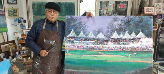 신정무 화백이 경기도 용인시 소재 화실에서 작품을 배경으로 포즈를 취하고 있다. 신정무 화백 제공