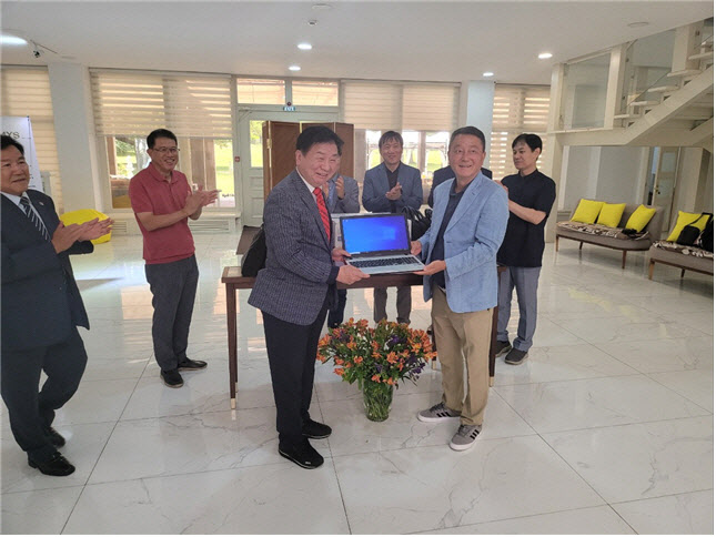 홍종수 이주민사회통합지원센터 고문이 강병구 한인회 회장에게 노트북을 전달하고 있다.