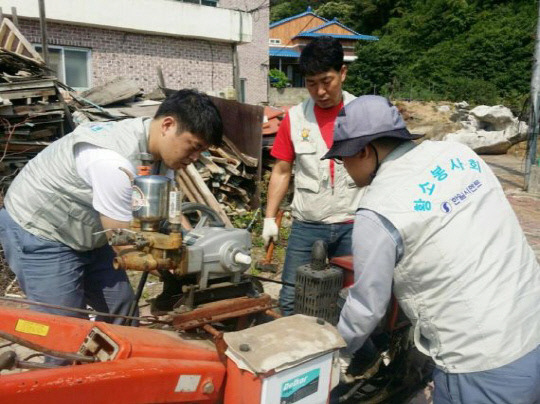 지역주민들의 농기계 수리에 구슬땀을 흘리고 있는 황소봉사회. 사진=한일시멘트