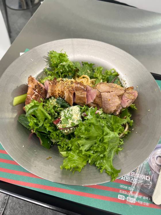 A pork pasta and salad dish from a Korean restaurant [SOFIA DEL FONSO]