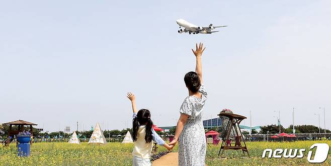 (인천=뉴스1) 박지혜 기자 = 26일 오후 인천 중구 운서동 인천공항 하늘정원을 찾은 어린이가 엄마와 함께 즐거운 시간을 보내고 있다.  인천국제공항공사는 인천공항 내 하늘정원에 이벤트가든 3만6000㎡를 조성해 이날부터 6월 11일까지 2주간 일반 시민들에게 무료로 개방한다.  하늘정원은 공사가 인천공항 동남측 유휴지(38만㎡)에 조성한 휴식공간으로 인천공항에 이·착륙하는 항공기의 모습과 자연 경관을 함께 즐길 수 있는 공항 명소다. 2023.5.26/뉴스1  Copyright (C) 뉴스1. All rights reserved. 무단 전재 및 재배포 금지.