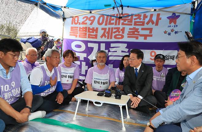 이재명 더불어민주당 대표가 28일 국회 앞에서 이태원 참사 특별법 제정을 촉구하며 단식 농성 중인 유가족을 만나고 있다. [연합]