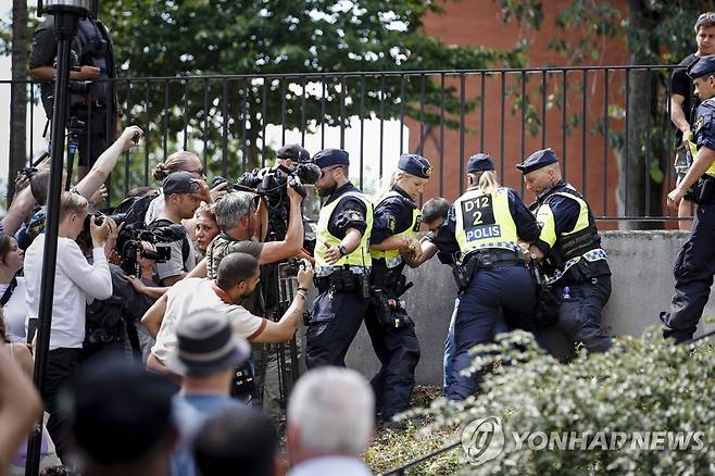 스웨덴에서 열린 '쿠란 소각' 집회 (스톡홀름 EPA=연합뉴스) 28일(현지시간) 스웨덴에서 벌어진 '쿠란 소각' 집회 현장에 경찰들이 시위 참가자들과 몸싸움을 벌이고 있다. 2023.6.29 photo@yna.co.kr